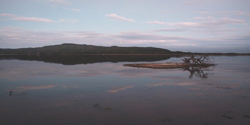 平静的湖面，多云的天空 · 免费素材图片