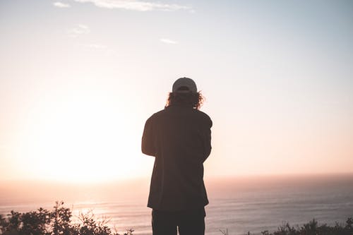 考虑在日落海景的匿名男子 · 免费素材图片