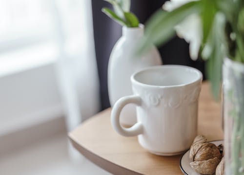 核桃在房子的桌子上的陶瓷杯附近 · 免费素材图片