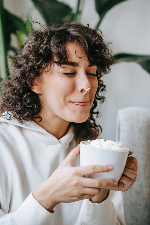 拿着白色陶瓷杯子的白衬衫的女人 · 免费素材图片