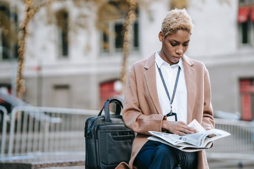 棕色外套阅读书中的女人 · 免费素材图片