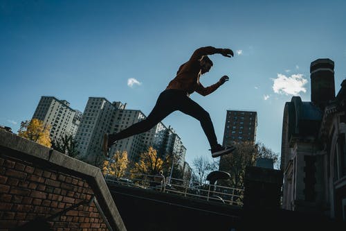 棕色夹克和黑色的裤子，在楼梯上跳跃的人 · 免费素材图片