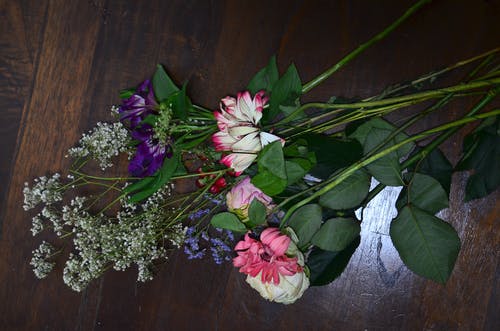 粉色和白色的花朵，棕色木制的桌子上 · 免费素材图片