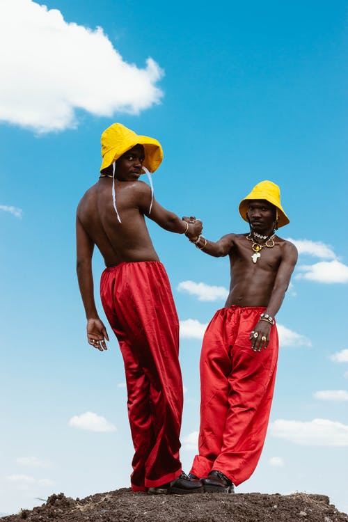 2名穿着红色裤子的人在蓝蓝的天空下戴黄色帽子 · 免费素材图片