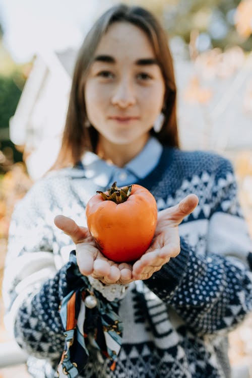 女人抱着一个大水果的照片 · 免费素材图片