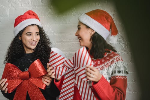 红色和白色圣诞老人帽子的女孩 · 免费素材图片