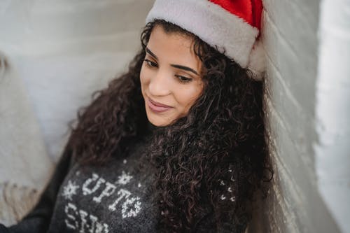 黑色和白色的毛衣，戴着红色和白色的圣诞老人帽子的女人 · 免费素材图片