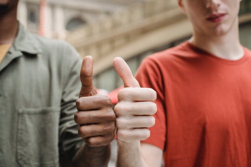 显示他的右手的红色船员领衬衫的男人 · 免费素材图片