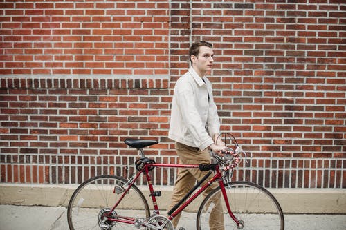 白色礼服衬衫和黑色的裤子，骑着红色自行车的人 · 免费素材图片