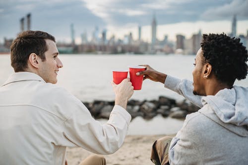 白色连帽衫喝红色陶瓷杯的男人 · 免费素材图片