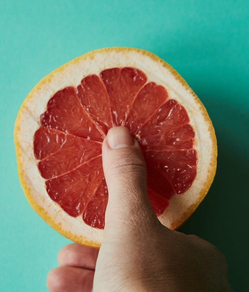 人控股切成薄片的橙色水果 · 免费素材图片