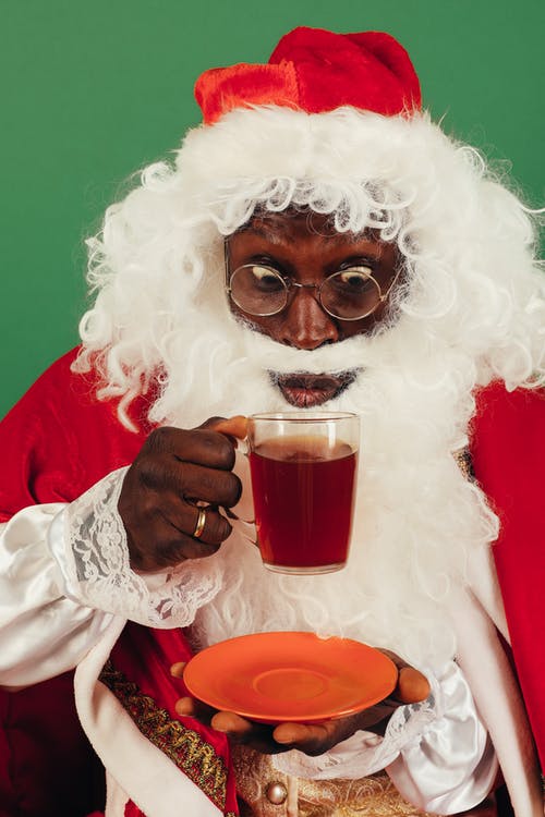 圣诞老人衣服的人喝热茶 · 免费素材图片