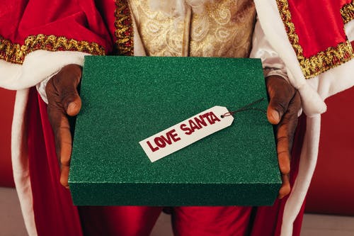 拿着礼物盒的圣诞老人服装的人 · 免费素材图片