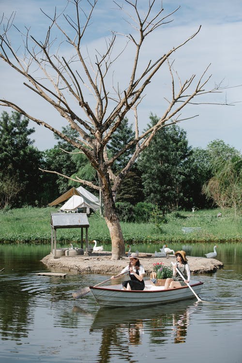 人们骑在河上的船上 · 免费素材图片