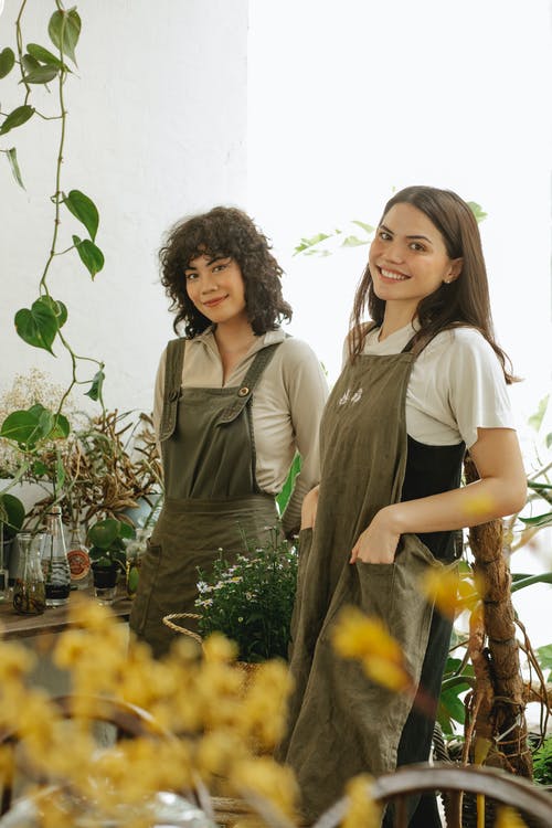 2名站在绿色植物旁边的女人 · 免费素材图片