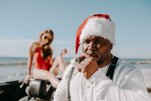 圣诞老人装抽着烟的男人 · 免费素材图片