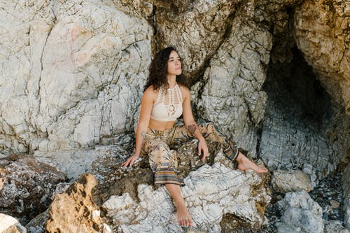 站在岩石地面上的棕色和黑色格子裙的女人 · 免费素材图片