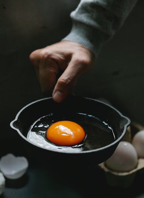 在黑碗上持有橙色水果的人 · 免费素材图片