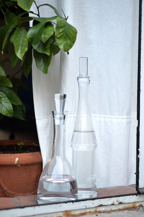 棕色陶壶上的透明玻璃瓶 · 免费素材图片