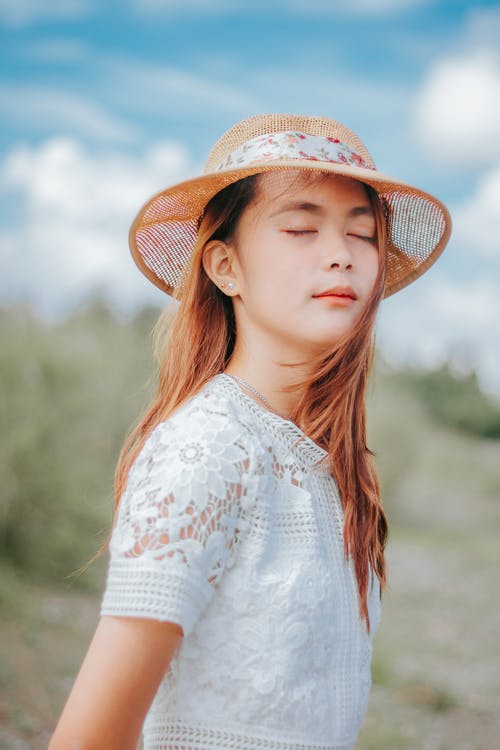 白色和红色的花衬衫，戴着棕色帽子的女人 · 免费素材图片