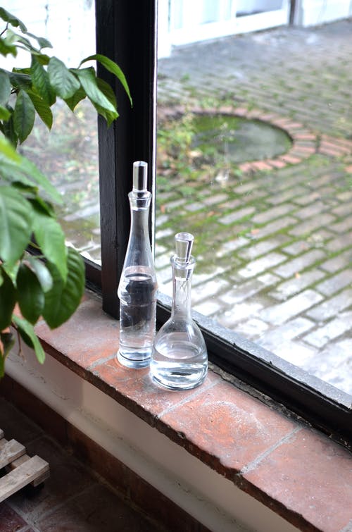 棕色的木桌上的透明玻璃瓶 · 免费素材图片