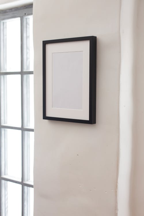白墙上的黑色木制框架 · 免费素材图片