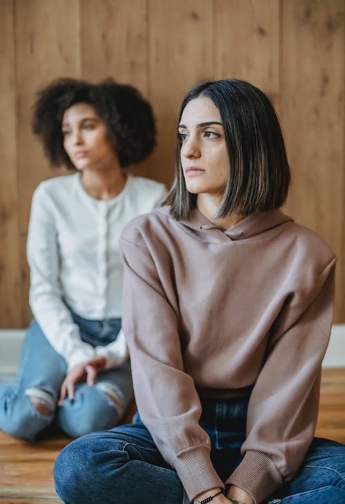 坐在白色毛衣的女人旁边的白色毛衣的女人 · 免费素材图片