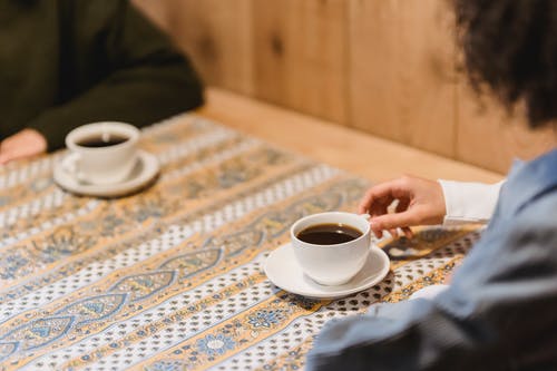 持白陶瓷杯碟的人 · 免费素材图片