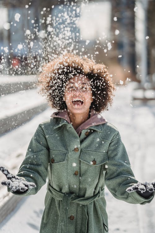绿色夹克站在雪地上的女人 · 免费素材图片