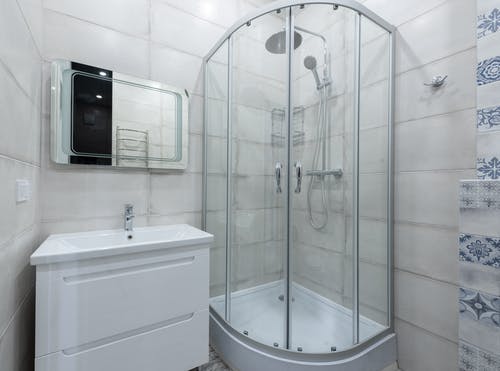白色陶瓷浴缸，配不锈钢淋浴喷头 · 免费素材图片