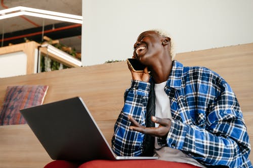 使用macbook的蓝白色和黑色格子衬衫的男人 · 免费素材图片