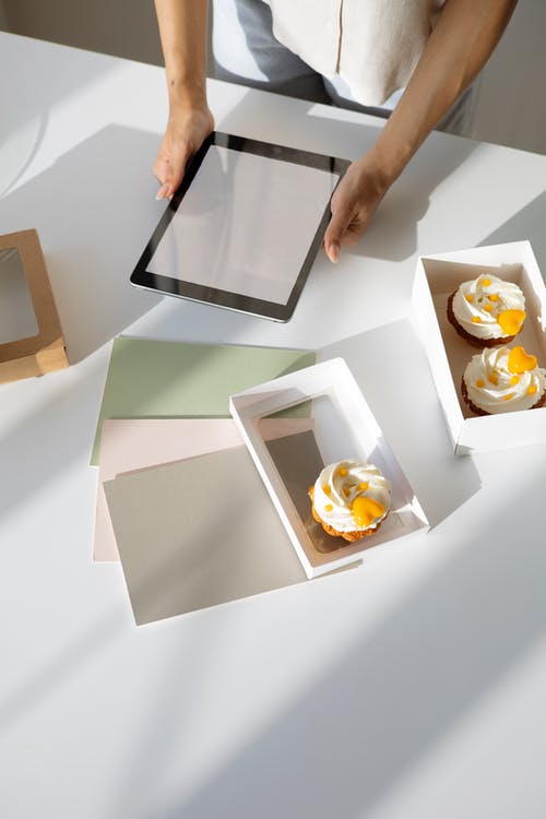 人拿着白色和棕色的盒子，用食物 · 免费素材图片