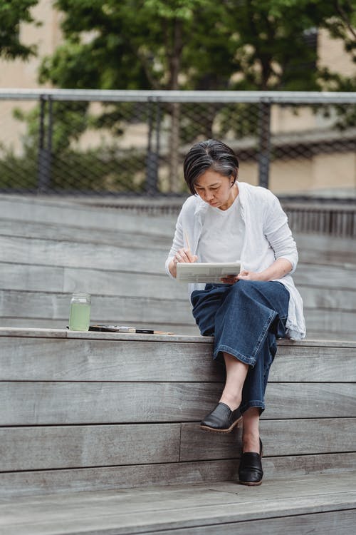 绘画时坐在木制漂白机上的女人 · 免费素材图片