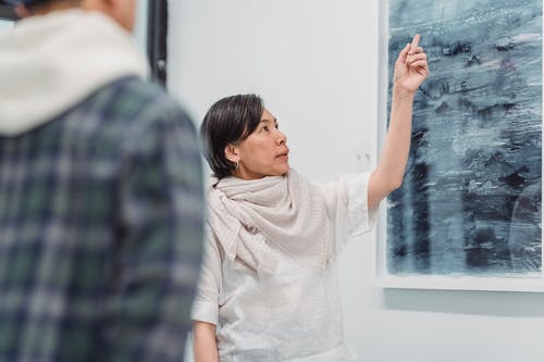 一个女人在谈论她的抽象画 · 免费素材图片