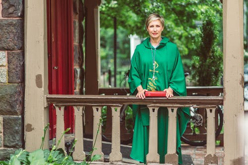 拿着圣经的绿色 Chasuble 的女人 · 免费素材图片