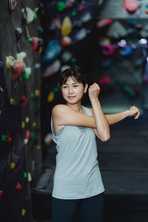 亚洲女人在抱抱健身房攀岩训练前伸胳膊 · 免费素材图片
