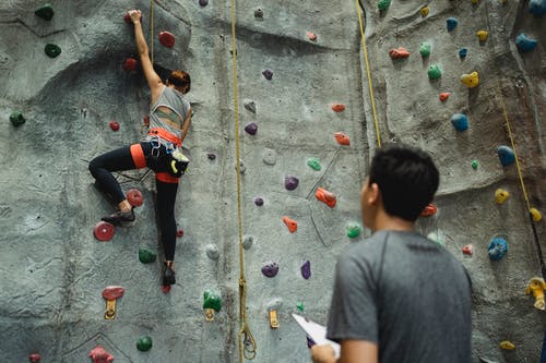 无法识别的民族教练和坚强的登山者攀岩 · 免费素材图片