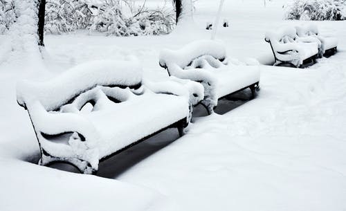 积雪覆盖的地面上的积雪的长凳 · 免费素材图片