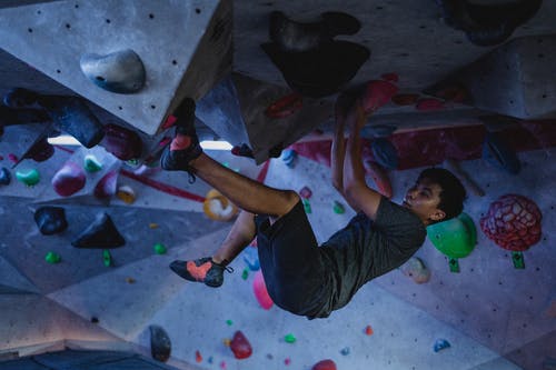 亚洲运动员攀岩墙在健身房 · 免费素材图片
