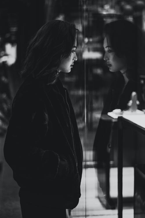 站在镜子旁边的黑夹克的女人 · 免费素材图片