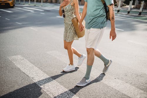 时尚夫妇过马路在人行横道上阳光灿烂的日子 · 免费素材图片