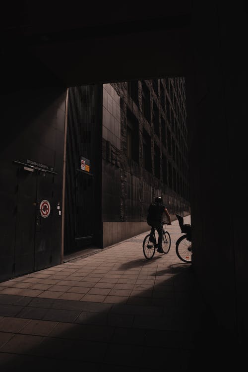 大楼附近骑自行车的人 · 免费素材图片