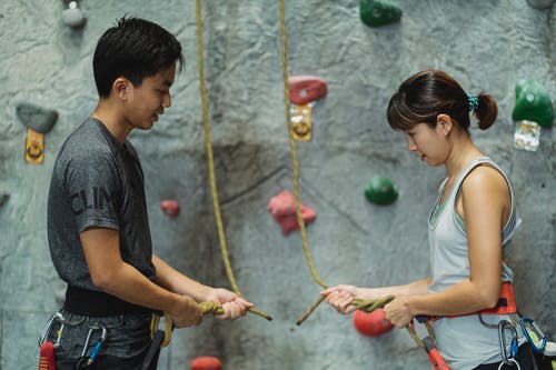 亚洲教练向登山家解释如何使用安全绳 · 免费素材图片