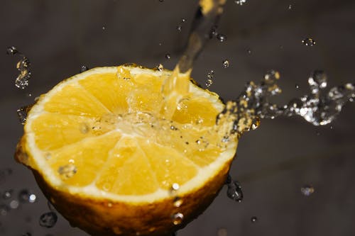 水倒在黄色柠檬片上的特写摄影 · 免费素材图片