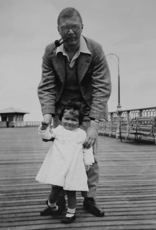 人站立和抱着他的孩子的灰度照片 · 免费素材图片