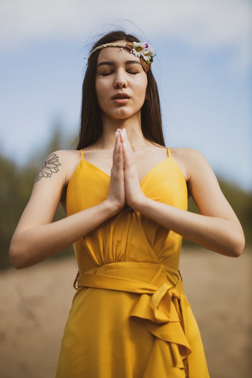 黄色礼服的妇女在祈祷的位置 · 免费素材图片