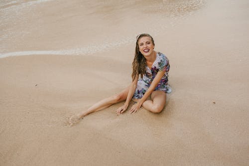 幸福的女人坐在沙滩上 · 免费素材图片