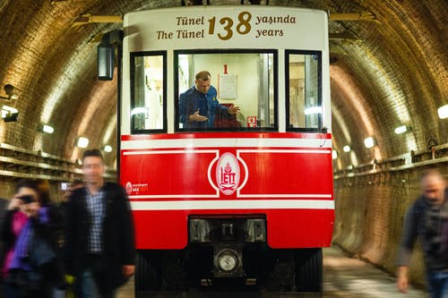 站在红色和白色火车旁边的人 · 免费素材图片