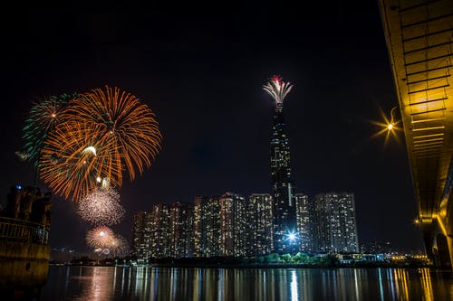 夜间城市建筑物上空的烟花汇演 · 免费素材图片