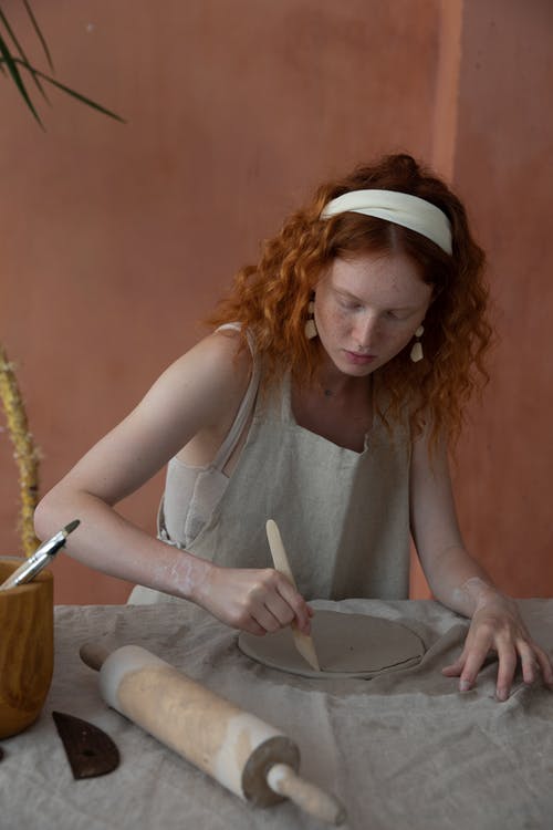 集中在陶器中的女人切割粘土板 · 免费素材图片